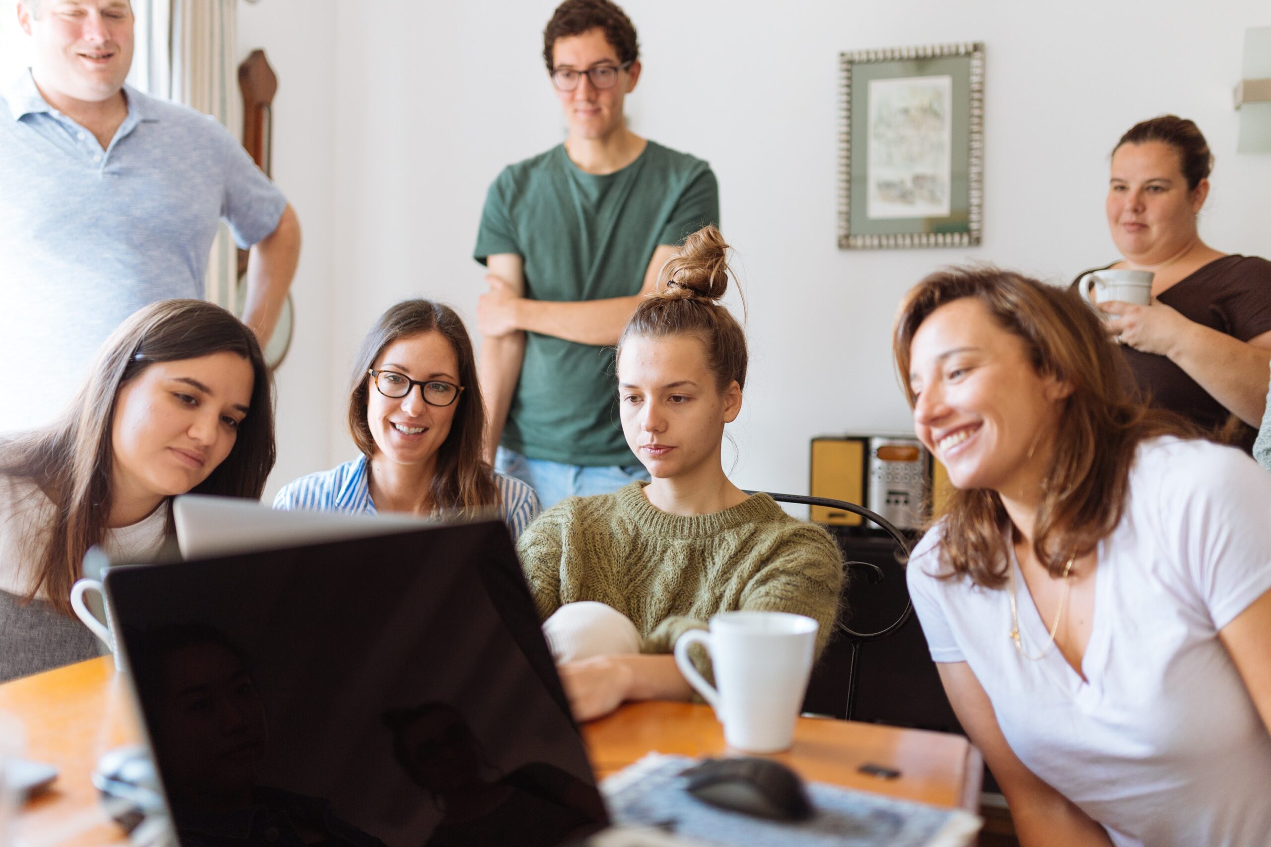 Grupa studentów patrzy na ekran komputera w pokoju